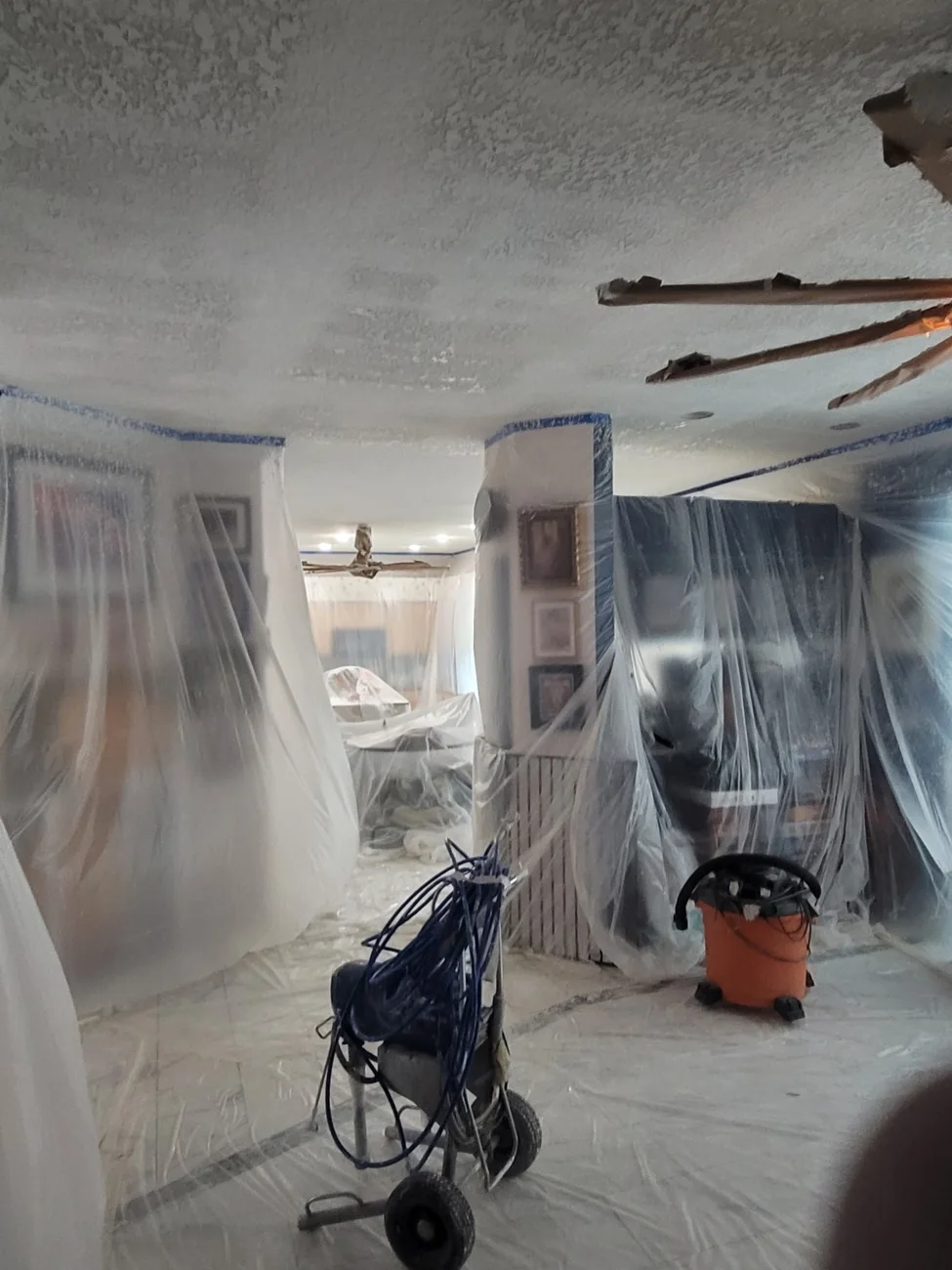 Home interior carefully covered in plastic sheeting during ceiling texture work